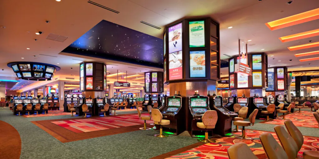 Casino floor at Resorts World Casino New York City with rows of slot machines and table games